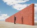 Mann schaut über Mauer